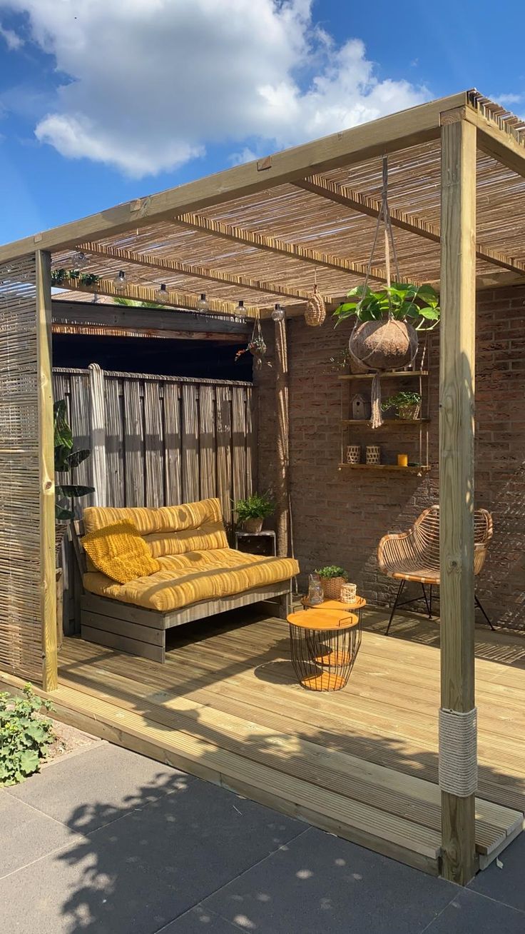 an outdoor living area with wooden furniture and plants