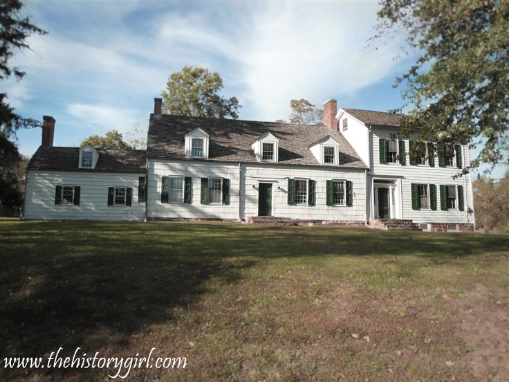 a large white house sitting on top of a lush green field