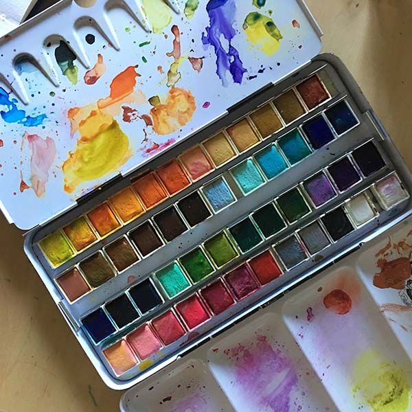 an artist's palette with watercolors in it