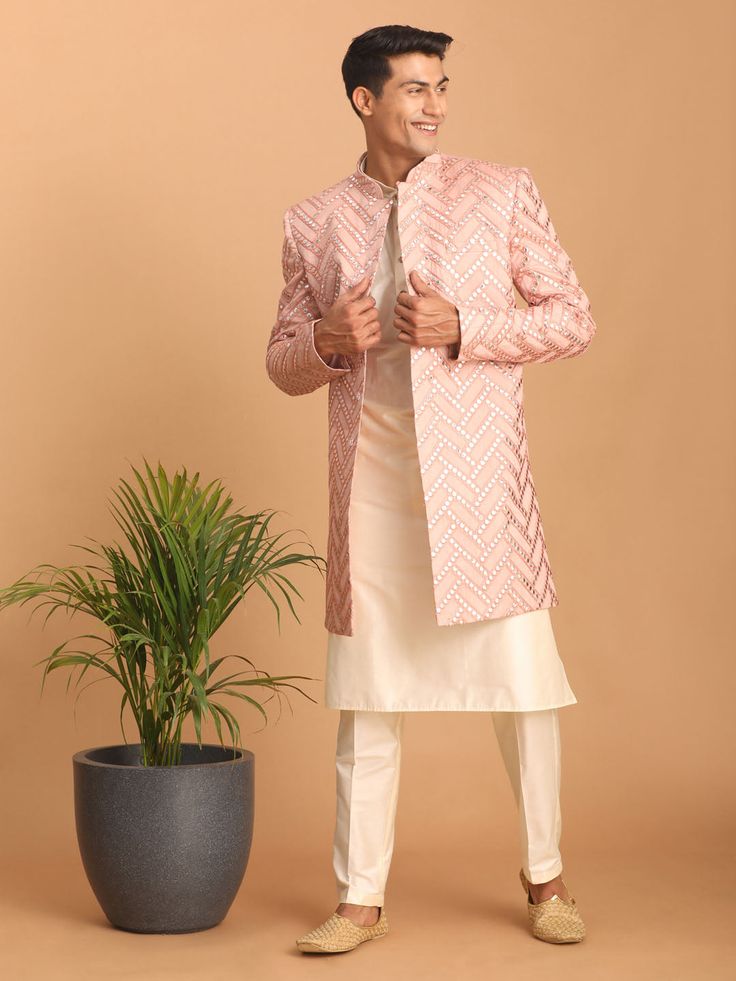 Vastramay Men's Pink Mirror Indo Western Sherwani with Kurta Pyjama Set Look impeccably stylish in this pink mirror work Sherwani set. Featuring a trendy Indo-Western design, the Sherwani boasts intricate mirror work and a mandarin collar, while the Kurta and Pyjama complement perfectly. Key Features Aqua blue mirror work design on Sherwani Mandarin collar, full sleeves on Sherwani, Kurta & Pyjama Cream colored Kurta and Pyjama Elasticated waistband with button closure on Pyjama Specifications S Pink Nehru Jacket For Festive Occasions, Designer Pink Nehru Jacket With Zari Work, Designer Sets With Gota Work For Eid, Designer Pink Sherwani With Pallu, Pink Nehru Jacket For Diwali With Traditional Drape, Pink Sherwani With Mirror Work In Straight Kurta Style, Festive Pink Nehru Jacket Straight Kurta, Designer Pink Sherwani With Pallu Detail, Designer Pink Sherwani With Cutdana