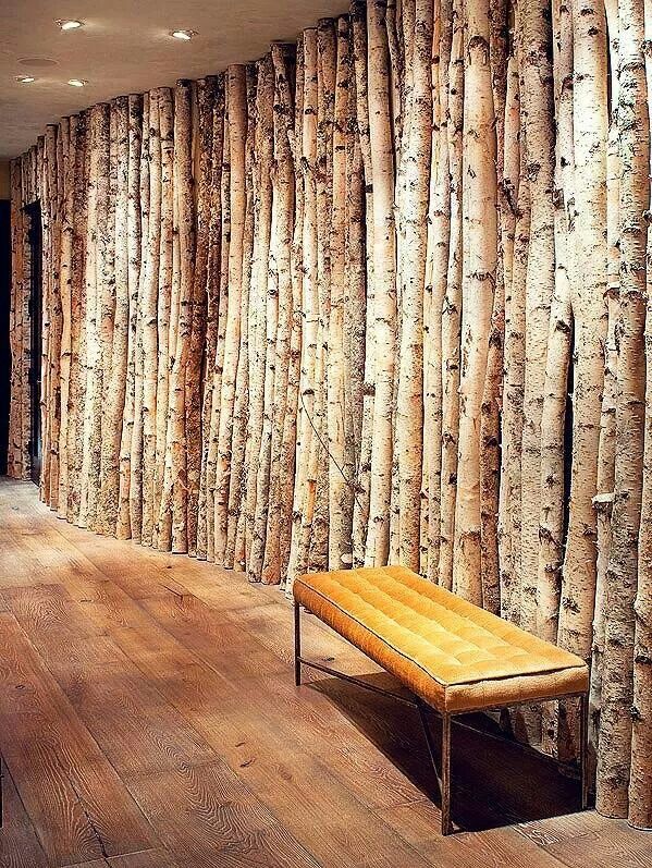 a room with wooden floors and walls that are lined with wood planks, along with a bench in front of the wall