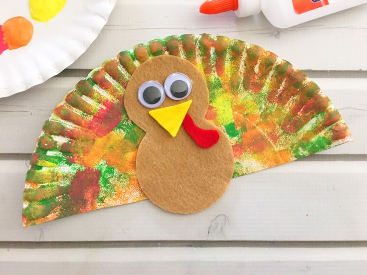 a paper plate with a turkey on it next to some crafting supplies and scissors