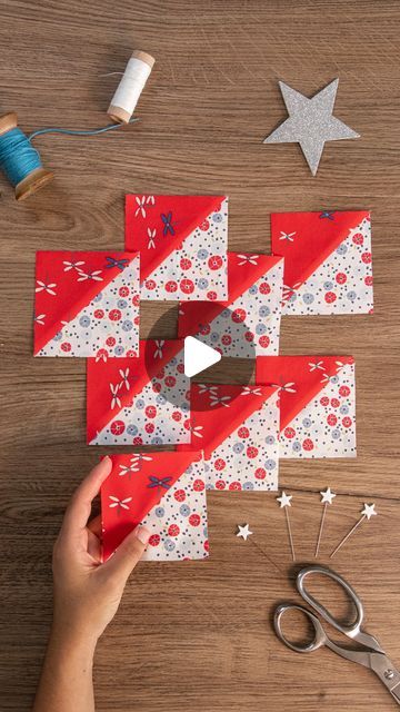 someone is cutting out some red and white paper to make an origami christmas tree