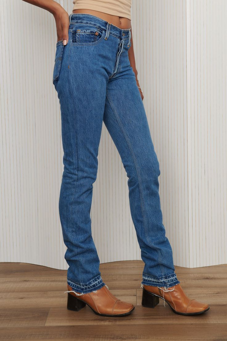 A unique pair of Levi's reworked denim jeans - featuring two tone pockets, frayed and exposed hem, and button fly. 100% Cotton. Waist: 27” - Hips: 36” - Rise: 9.5” - Inseam: 36” - Leg Opening: 7”. Fits like 26-27. Model is waist size 26. High Rise Medium Wash Jeans With Contrast Stitching, Medium Wash Mid-rise Jeans With Contrast Stitching, Mid-rise Medium Wash Jeans With Contrast Stitching, Fitted Rigid Denim Jeans In Denim Blue, Fitted Flare Jeans With Frayed Hem In Rigid Denim, High Rise Denim Flare Jeans With Contrast Stitching, Fitted Jeans With Frayed Hem And Standard Cut Leg, Fitted Rigid Denim Flare Jeans In Dark Wash, Fitted Dark Wash Flare Jeans In Rigid Denim