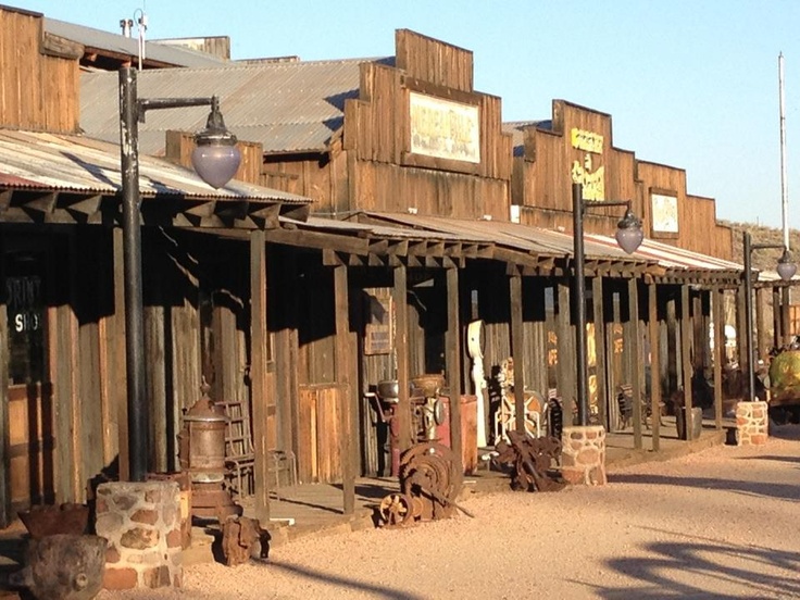 an old western town with wooden buildings and lots of rusted out items on the street