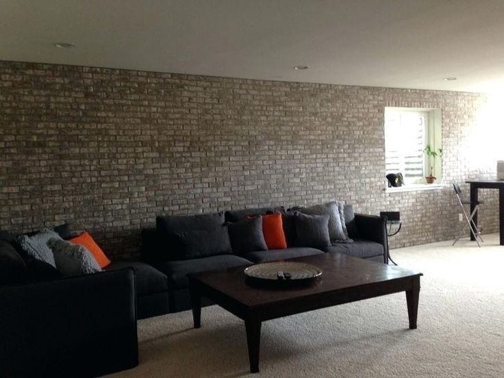 a living room filled with furniture and a brick wall behind the couch is a coffee table