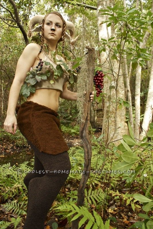 a woman in a costume standing next to a tree