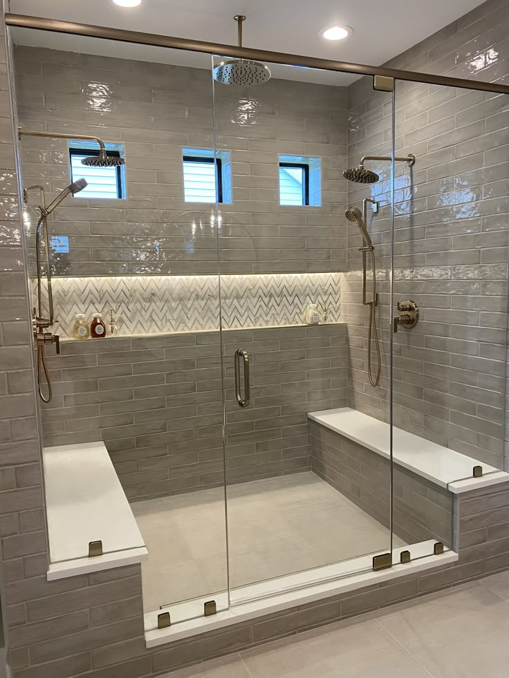 a walk in shower sitting next to a bath tub under two windows on top of a tiled floor