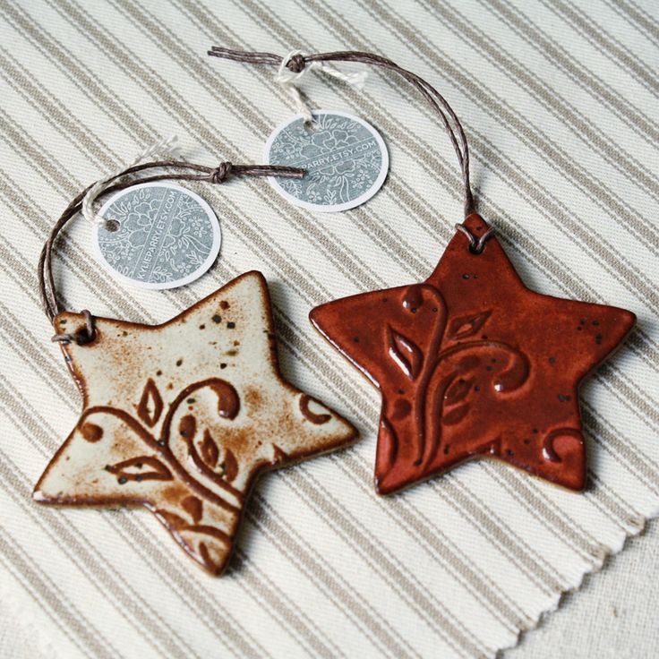 two brown and white ceramic ornaments on a striped cloth