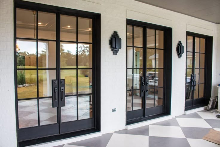 an open patio with black doors and checkered flooring