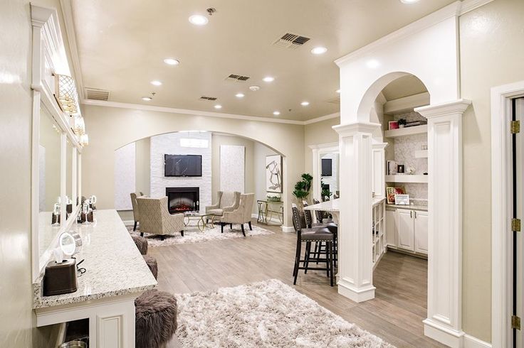 a living room filled with furniture and a fire place next to a kitchen counter top