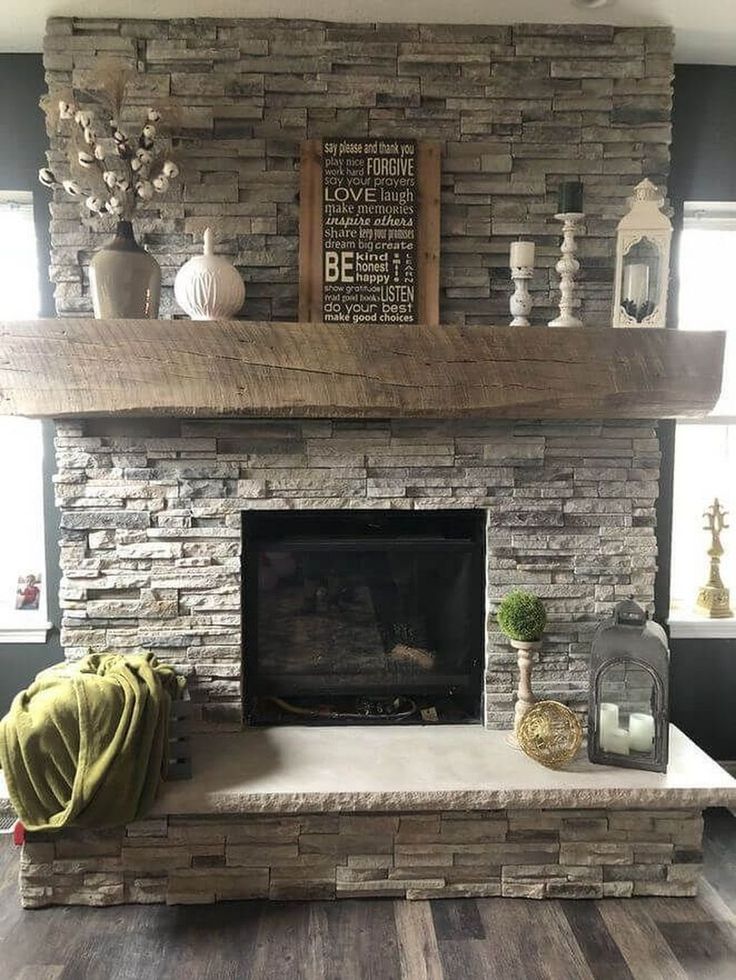 a living room with a stone fireplace and wood floors