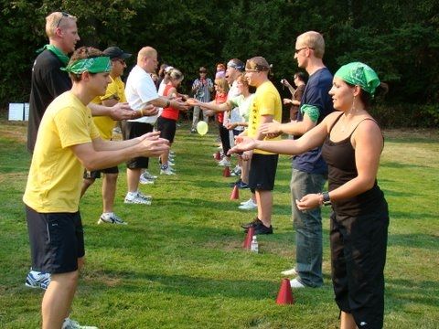 a group of people standing on top of a lush green field holding frisbees