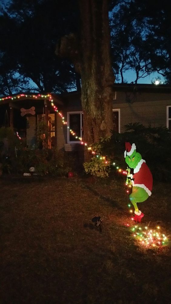 a christmas light display in front of a house with the grino on it's side