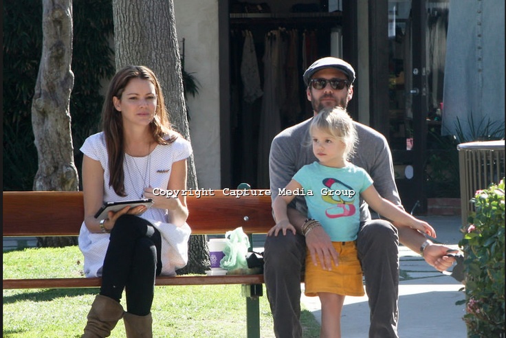 a man and woman sitting on a bench with a child