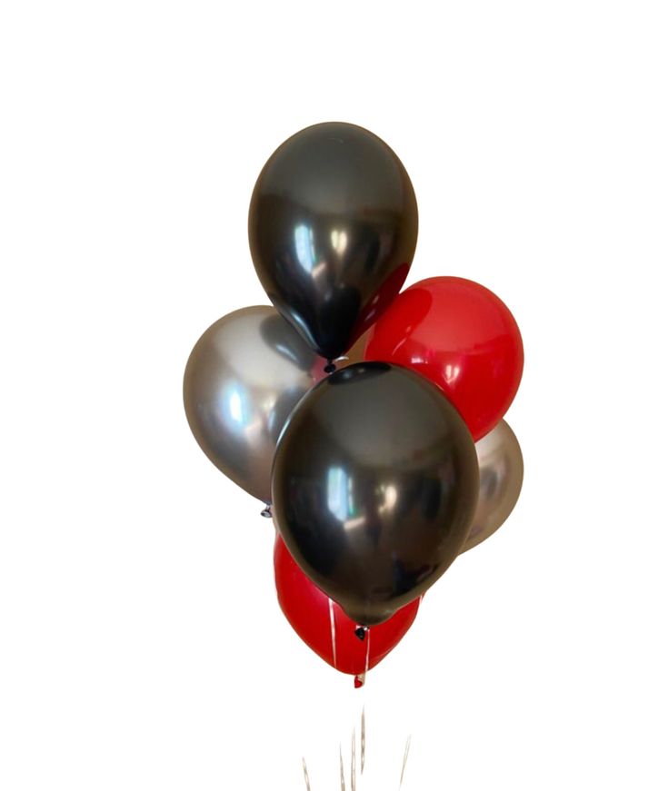 a bunch of black and red balloons floating on top of each other in the air