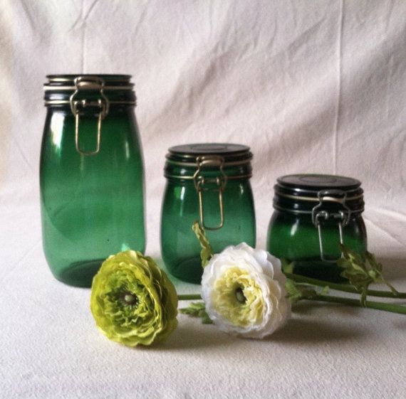 three green mason jars with flowers in them