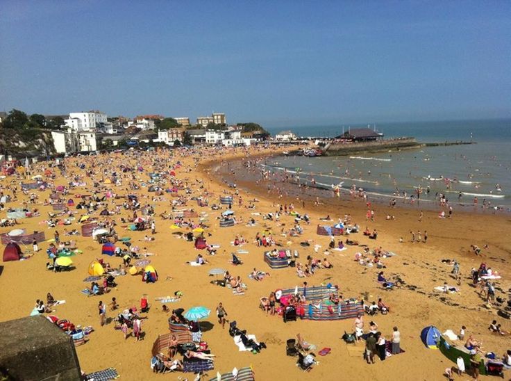 many people are at the beach on a sunny day