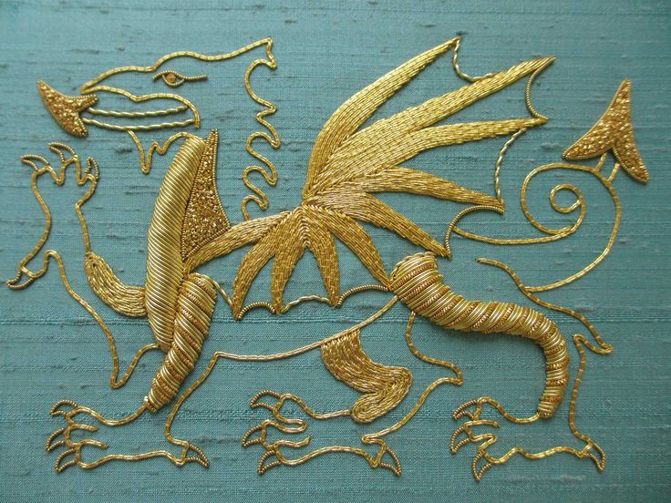 a piece of art that is made out of wood and has gold thread on it