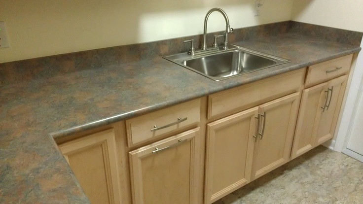 an empty kitchen with granite counter tops and stainless steel sink faucet in the corner