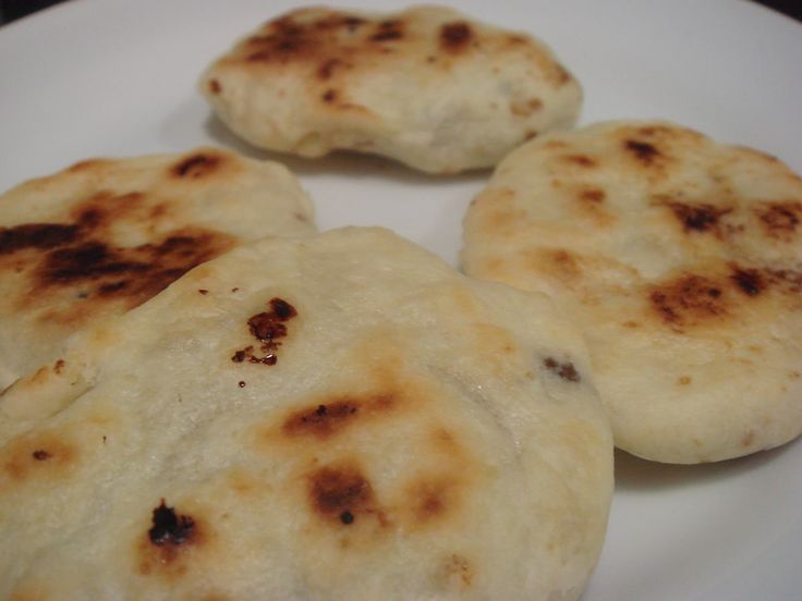 four flat breads sitting on top of a white plate