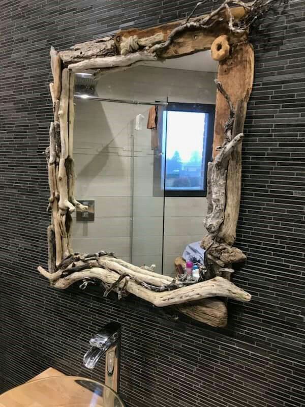 a bathroom with a sink and mirror made out of driftwood