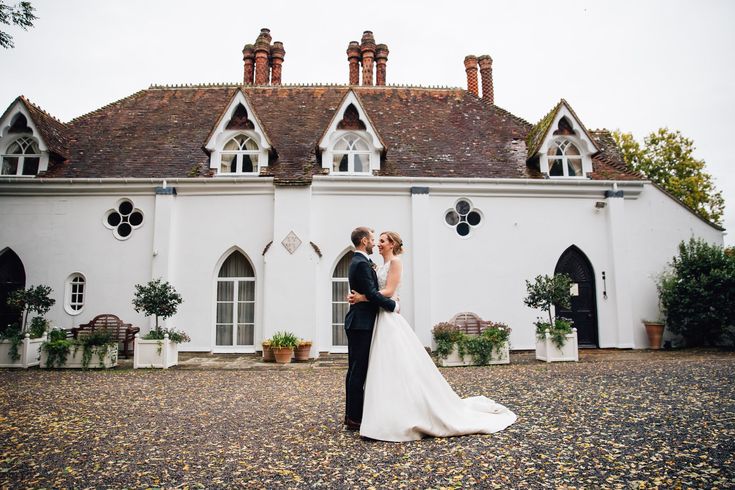 a bride and groom standing in front of a white building