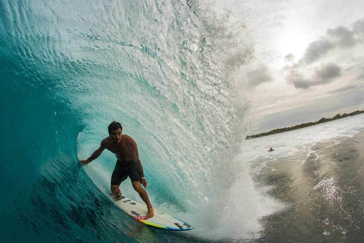 a man riding a wave on top of a surfboard