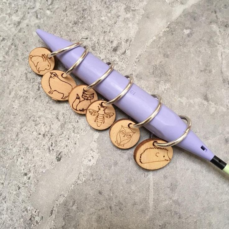 a purple pen sitting on top of a table next to some wooden discs and magnets