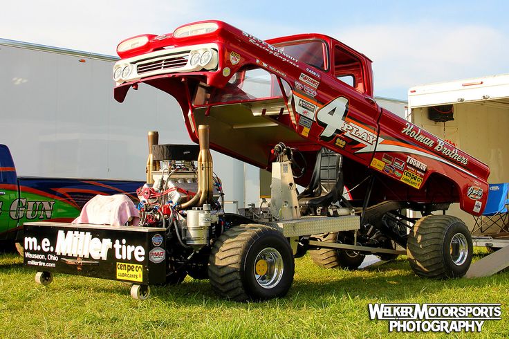 a large truck with an open hood on it's flatbed is parked in the grass