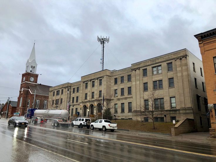 several cars are parked on the side of the road in front of an old building