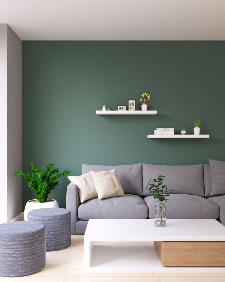 a living room with green walls and white furniture in the corner, including a gray couch