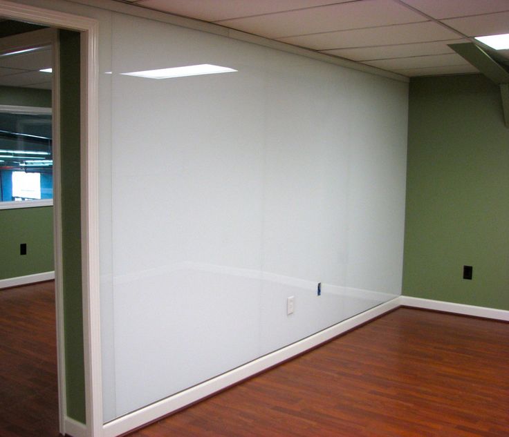 an empty room with hard wood floors and green walls