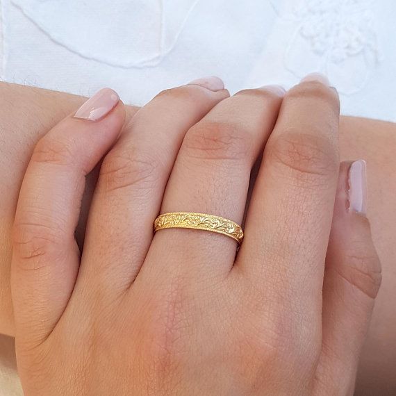 a woman's hand with a gold ring on it