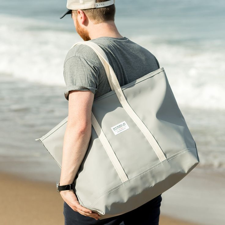 Step out in style with our stunning Grey Steeletex Zip Top Beach Tote. Crafted from durable vinyl, this chic tote is both water and tear-resistant, ensuring it stays pristine with minimal effort. The elegant 10" handle drop allows you to carry it over your shoulder effortlessly, freeing your hands, so you can do things like sending quick texts and enjoying your coffee. Featuring a zippered top and an interior pocket, this tote keeps your essentials secure and organized, making it the perfect acc Sea Colour, Beach Tops, Beach Tote, Tote Bag, Vinyl, Grey