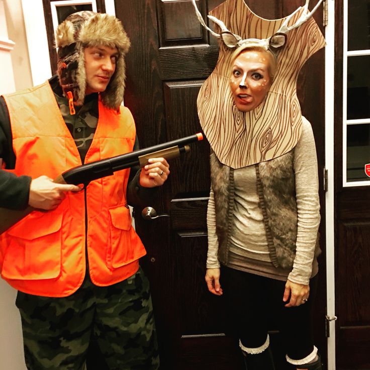 two people in costumes standing next to each other near a door with an animal head on it