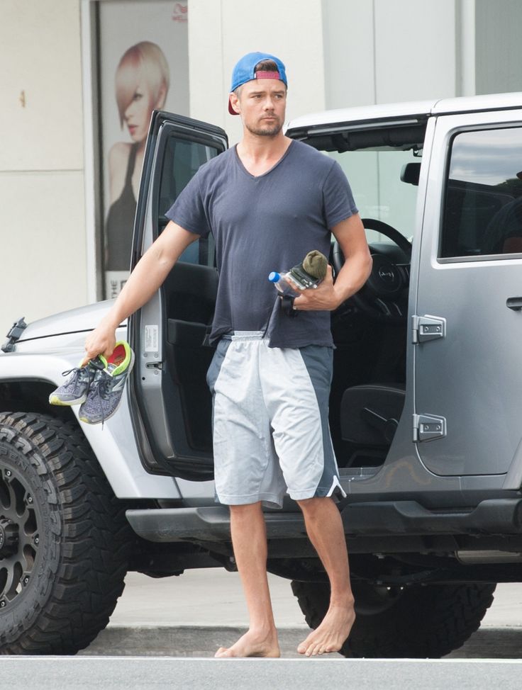 a man standing in front of a gray jeep