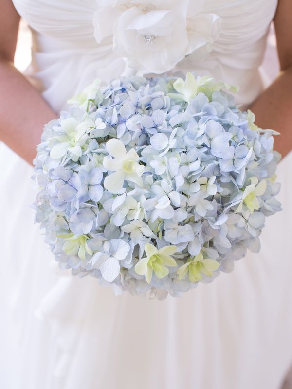 a bride holding a bouquet of blue and white flowers