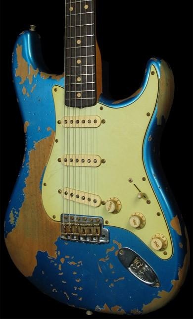 an old blue and yellow electric guitar with faded paint on it's body, in front of a black background