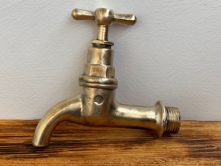 a brass faucet sitting on top of a wooden table