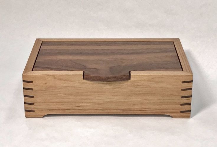 a wooden box with two compartments on the bottom and one drawer open to show something inside