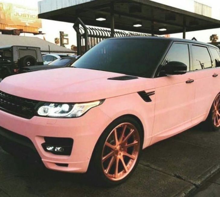 a pink range rover parked in front of a gas station with other cars behind it