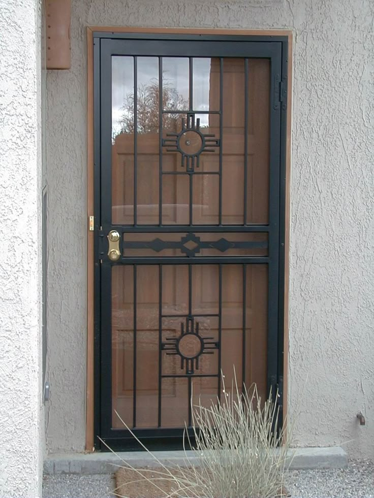 the door is open and there is a plant next to it on the side of the building