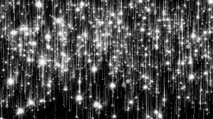 black and white photograph of falling lights on a dark background with stars in the sky