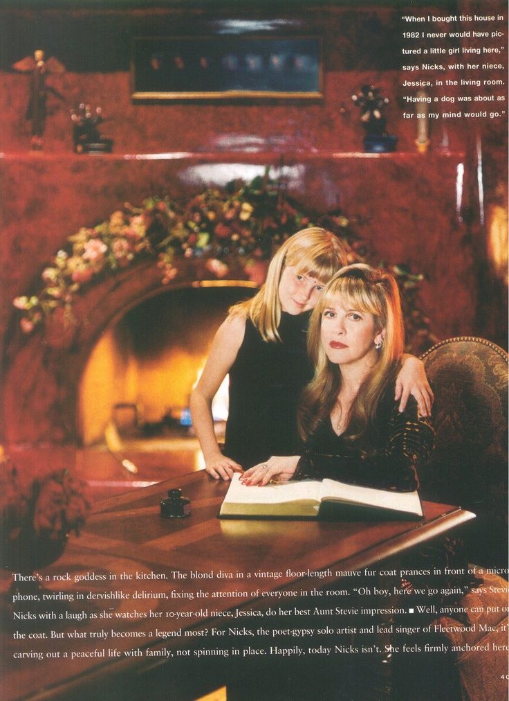 two women sitting at a table with an open book