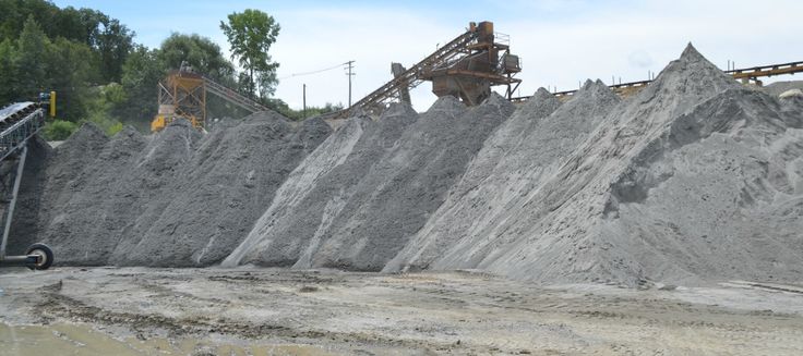 a large pile of dirt sitting next to a forest