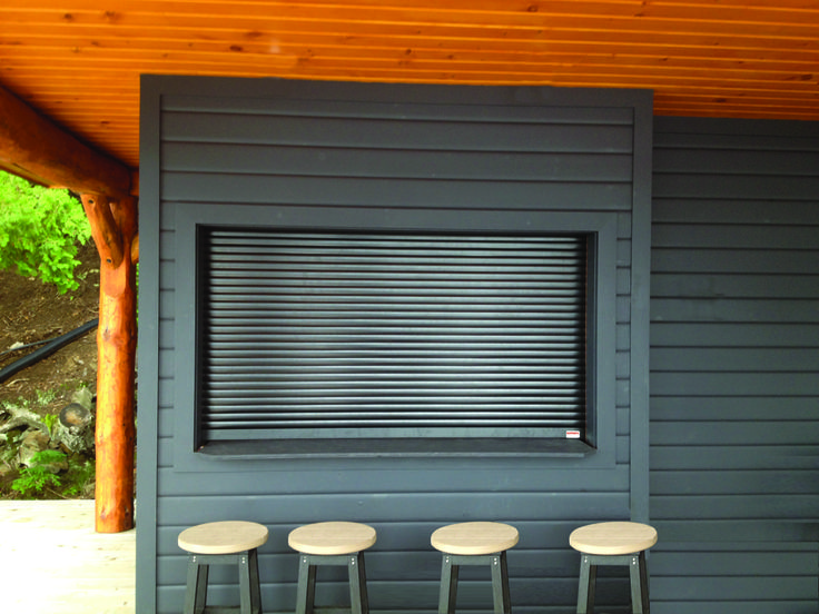 three stools sitting in front of a window with shutters on the outside wall