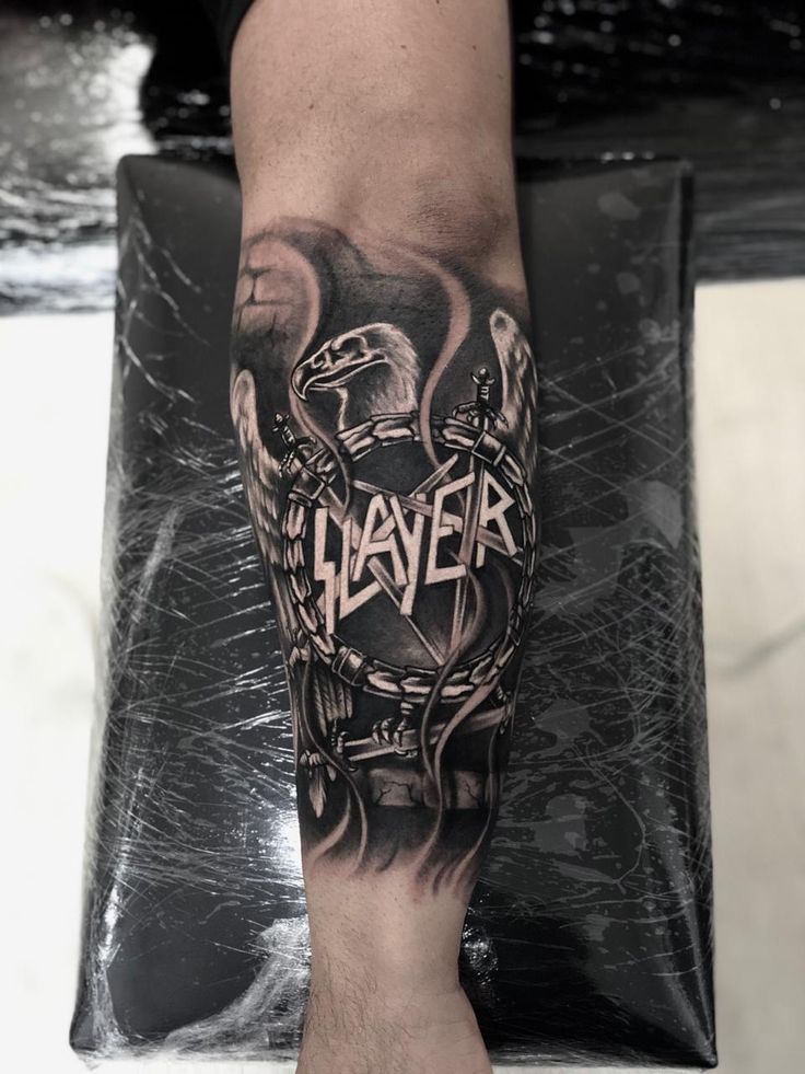 a man's arm with a tattoo on it that says slayer and an eagle