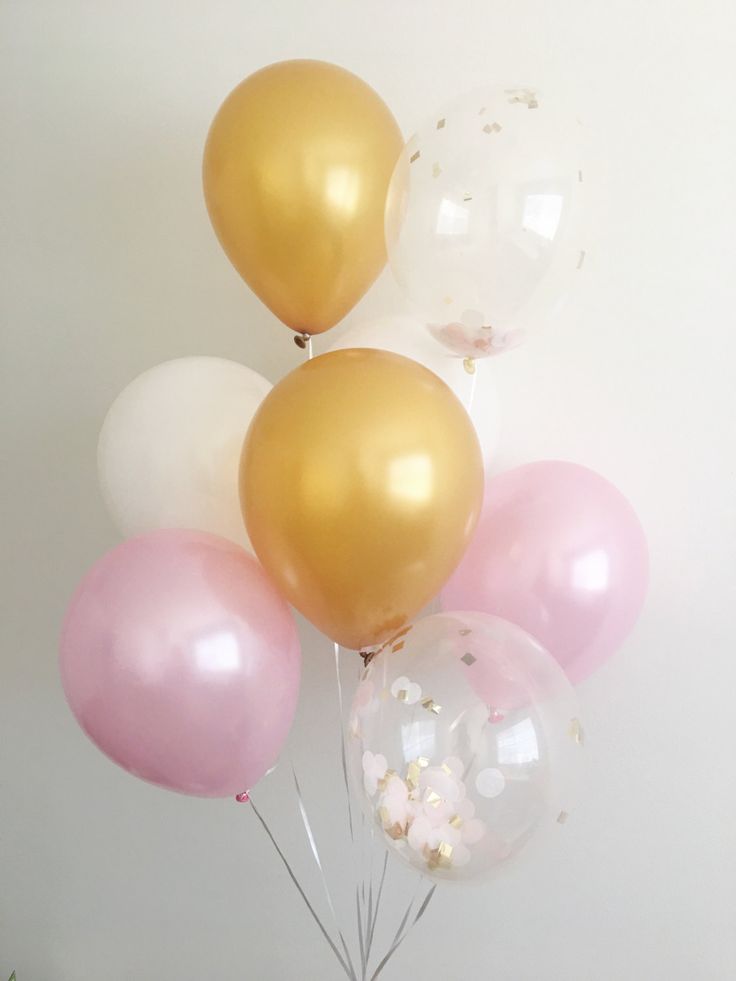 a bunch of balloons that are sitting in the air with some white and pink ones