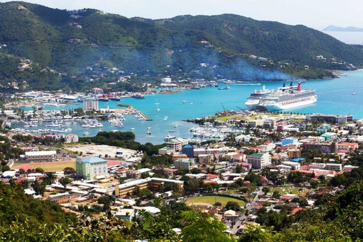 an aerial view of a city with boats in the water and mountains in the background